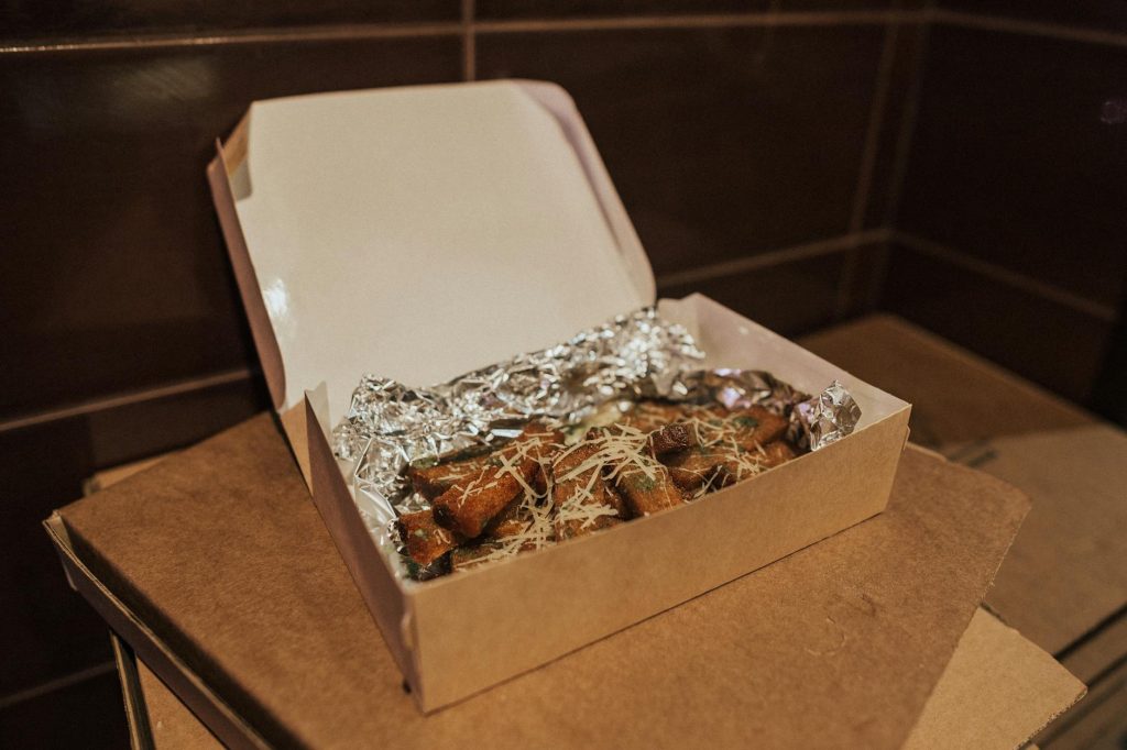 Delicious fried food in an open box lined with foil, ready to eat.