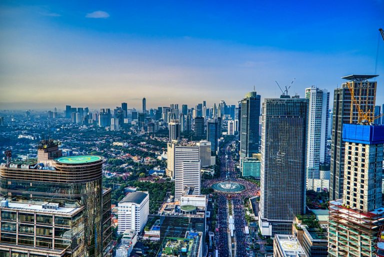 A breathtaking aerial view of Jakarta's urban skyline during the day, showcasing skyscrapers and city life.