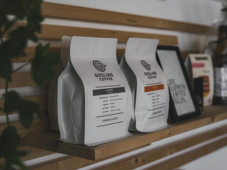 Stylish showcase of Gosling Coffee packaging with wooden accents on a shelf indoors.