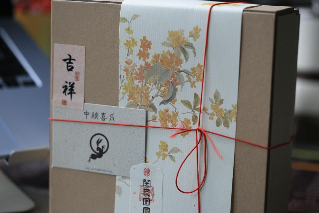 A beautifully wrapped gift box featuring floral design and Chinese calligraphy, perfect for festive occasions.