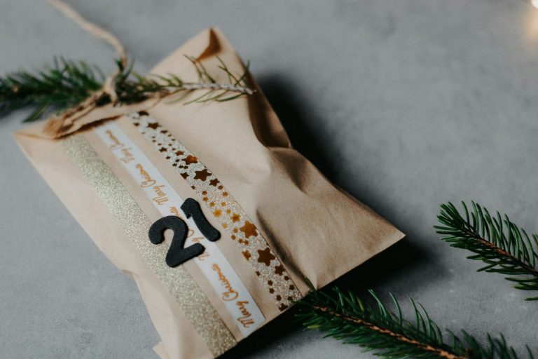 Close-up of a decorated paper bag as festive advent calendar gift on gray background.