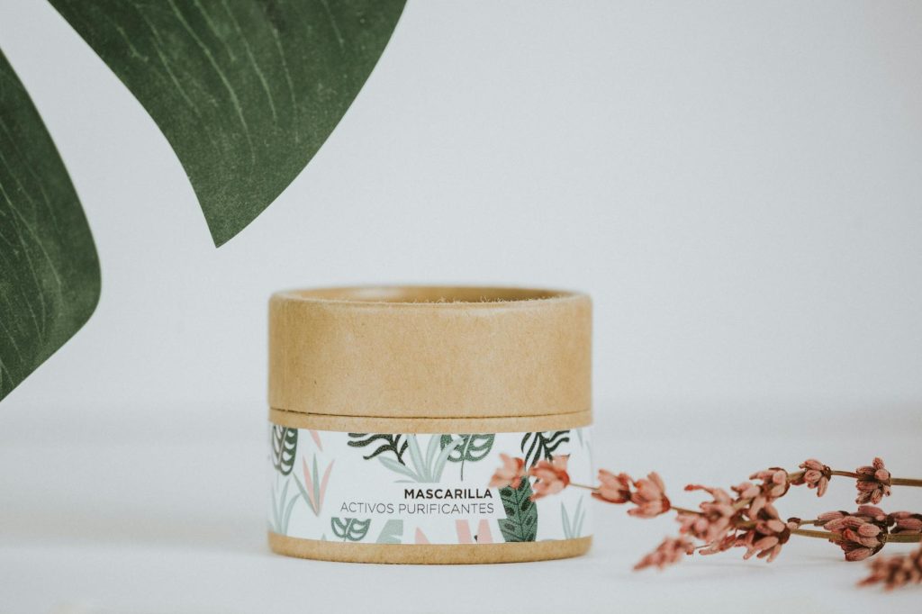 Minimalist shot of a natural cosmetic product in eco-friendly packaging, surrounded by greenery.