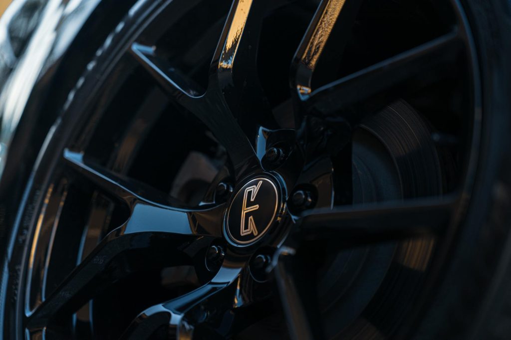 Detailed view of a glossy black alloy wheel rim highlighting its sleek and modern design.