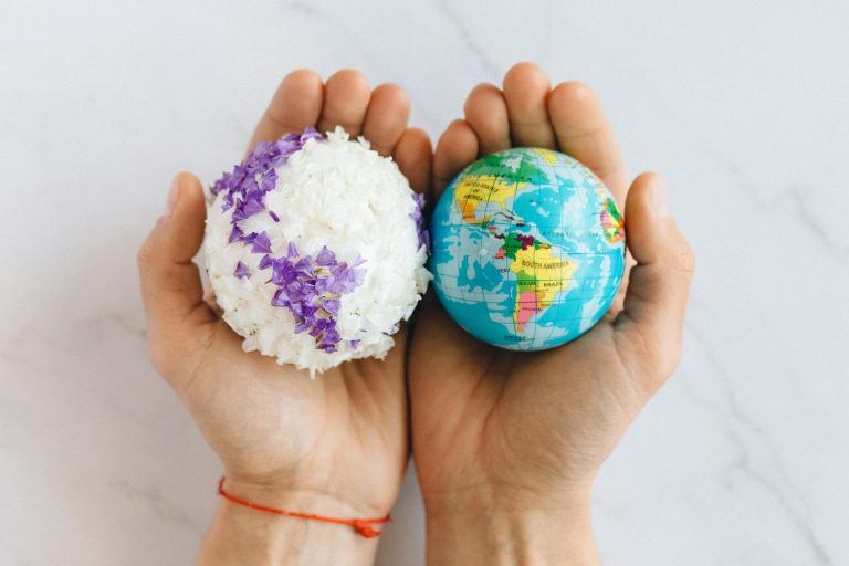 Hands holding a globe and floral sphere, symbolizing care for the planet.