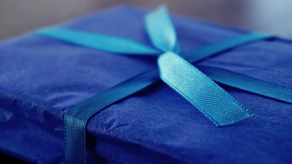 Close-up of a blue gift box with a matching ribbon, perfect for celebrations.
