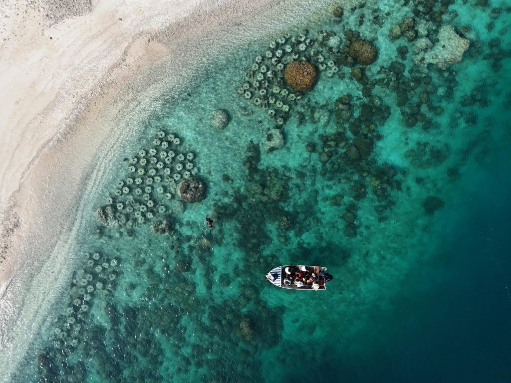 Stunning aerial view of coral reefs and a small boat in Jakarta. Perfect for travel and nature themes.