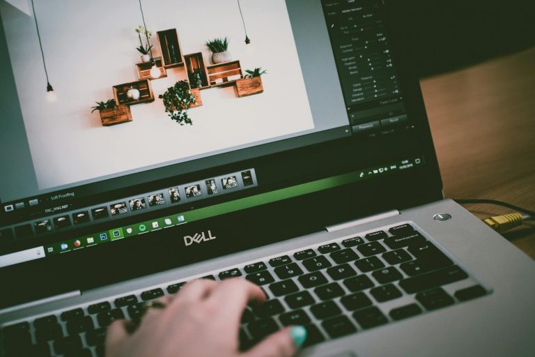 User working on photo editing software on a Dell laptop in a stylish indoor setting.