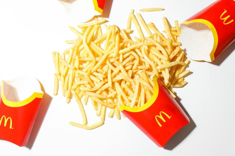 Delicious McDonald's French fries spilled on a bright white background.