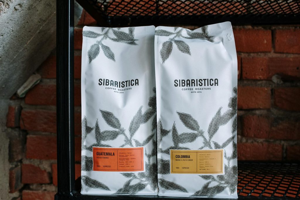 Elegant coffee packaging displayed on industrial shelving in a café.