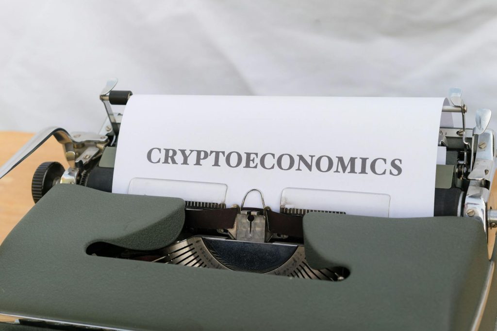 A vintage typewriter printing the term 'Cryptoeconomics', blending old technology with modern finance.