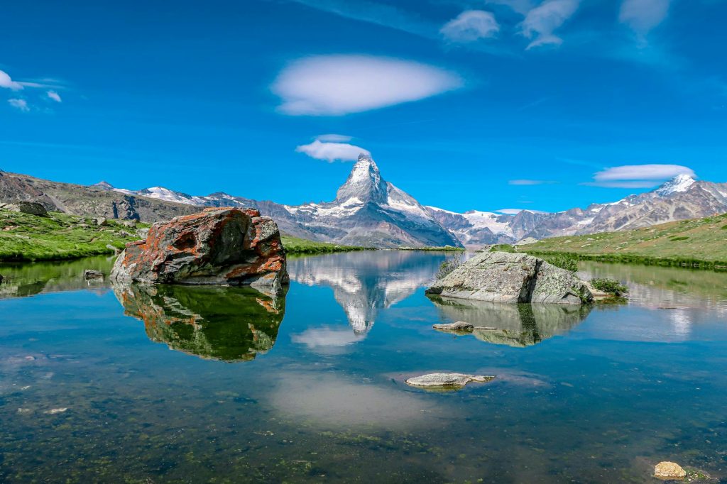 Breathtaking reflection of the Matterhorn mountain in a pristine Swiss alpine lake under clear skies.
