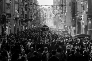 A vibrant, crowded street scene featuring a tram surrounded by people.
