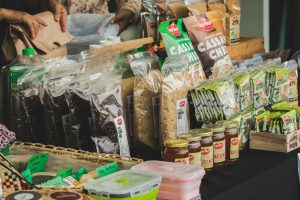 An assortment of packaged foods displayed on a market stall indoors, showcasing variety.