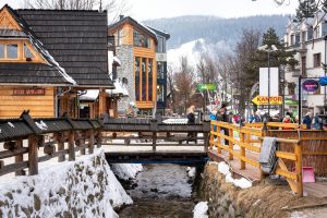 Charming winter view of Zakopane's snowy streets and wooden architecture.