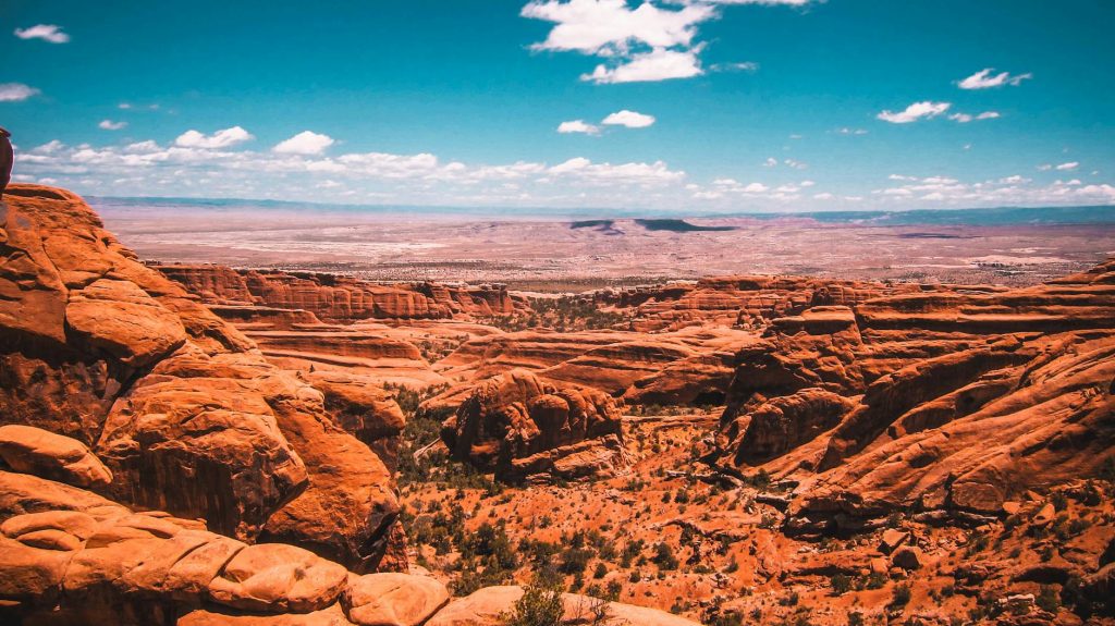 Beautiful view of a red rock desert canyon under a clear blue sky, showcasing natural geological formations.