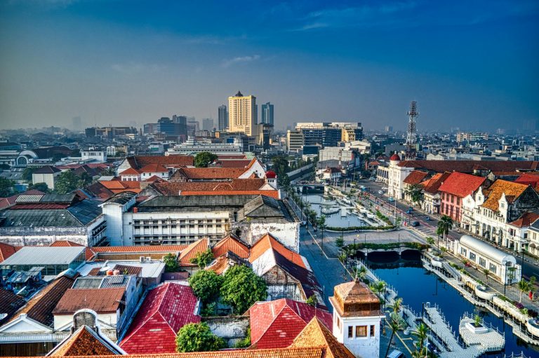 Aerial view of Jakarta's historic district with a vibrant cityscape and waterfront canal.