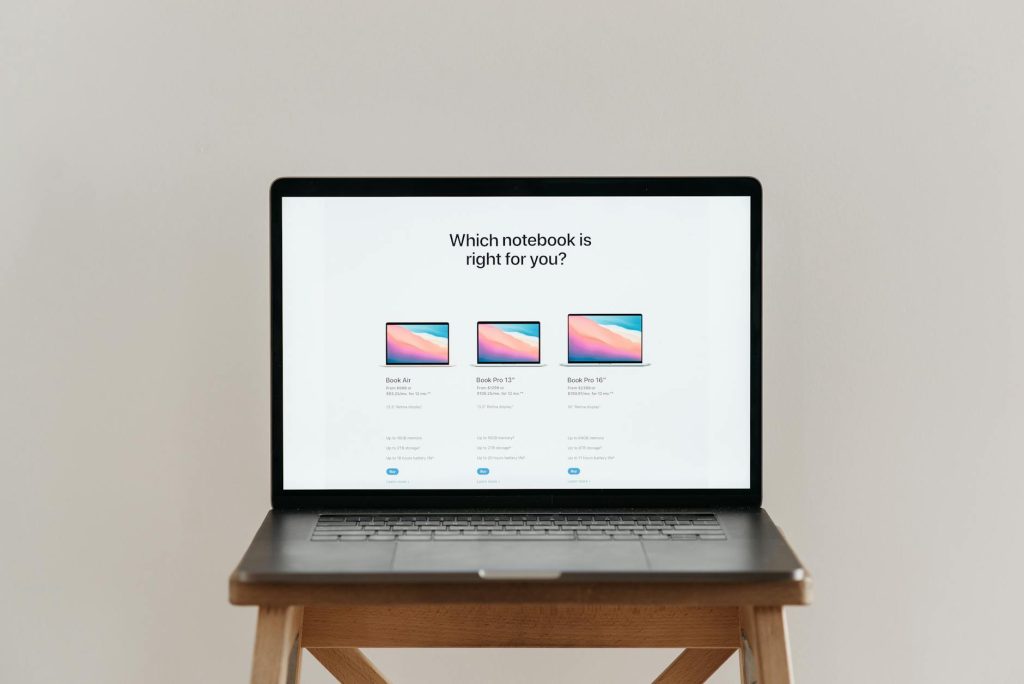 An open laptop on a wooden stool showing a notebook comparison chart, ideal for tech-focused imagery.