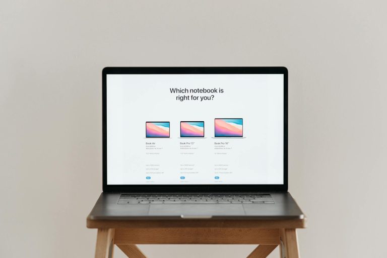 An open laptop on a wooden stool showing a notebook comparison chart, ideal for tech-focused imagery.