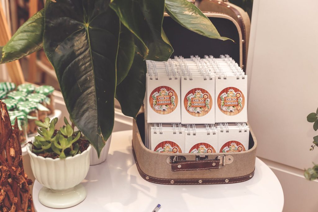 Stylish notepad display surrounded by lush green plants on a table.