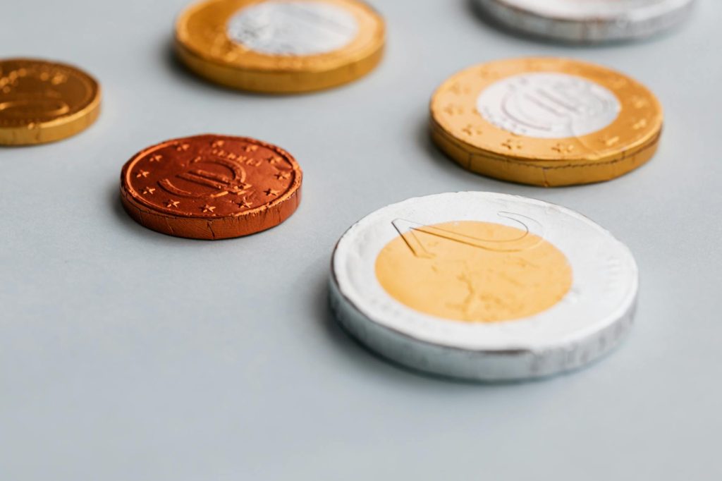 High-angle view of foil-wrapped chocolate coins on a desk, perfect for festive and gifting concepts.