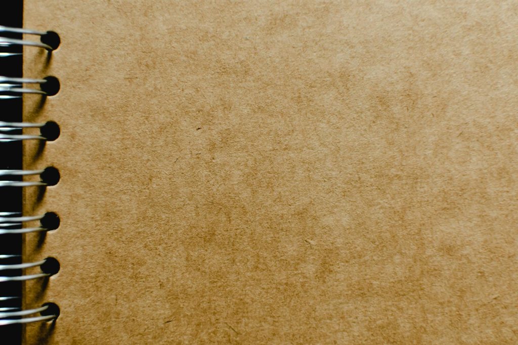 Detailed close-up of a spiral notebook with a focus on the kraft paper cover texture, ideal for design mockups.