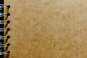 Detailed close-up of a spiral notebook with a focus on the kraft paper cover texture, ideal for design mockups.