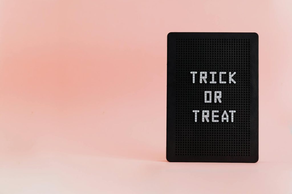 Minimalist Halloween sign with 'Trick or Treat' text on a pink background, ideal for holiday designs.