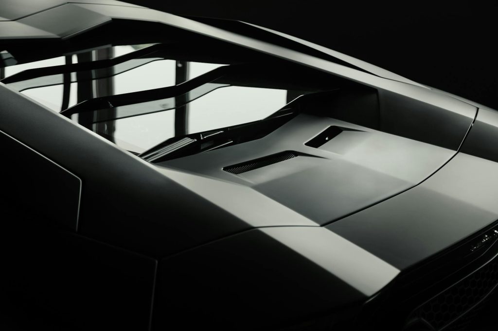Close-up of a sleek luxury sports car with a modern geometric design, highlighting its aerodynamic features.