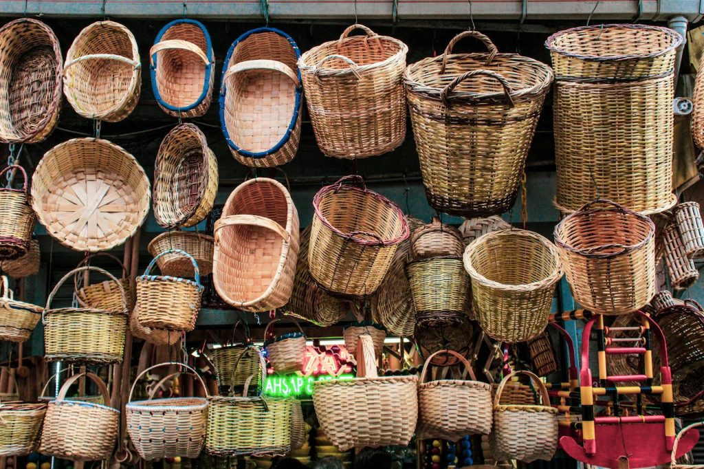 Colorful assortment of handcrafted baskets hanging in a traditional market shop.