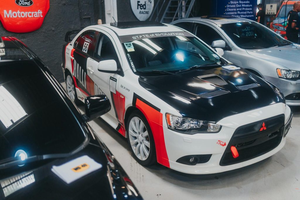 Detailed view of a customized Mitsubishi Lancer Evolution on display in a garage setting.