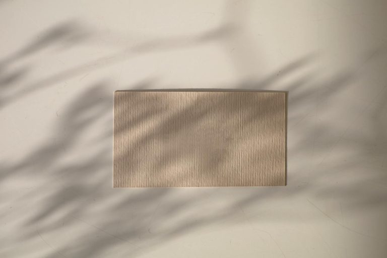 Textured blank card placed on a light surface with soft shadows, ideal for design mockups.