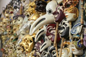 Colorful venetian masks in a market representing traditional Italian craftsmanship.