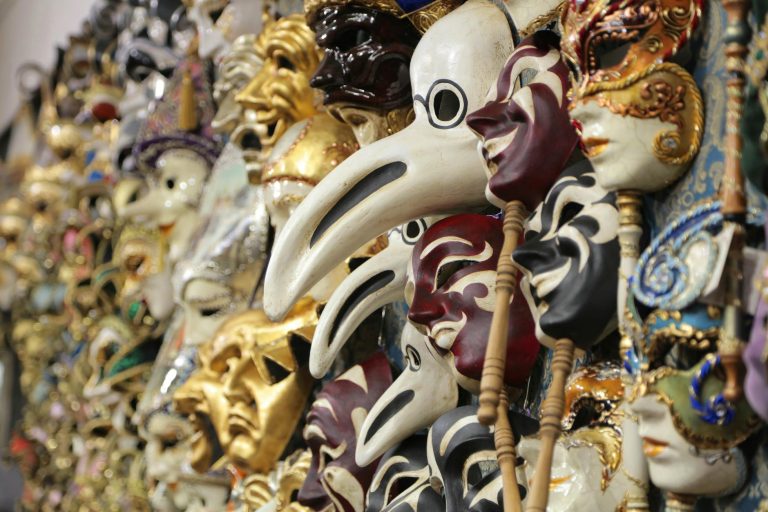 Colorful venetian masks in a market representing traditional Italian craftsmanship.