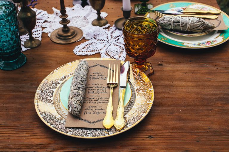 A beautifully arranged rustic fine dining table with vintage cutlery and plates, perfect for special occasions.
