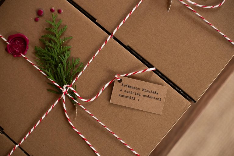Rustic gift box tied with twine, adorned with a fir sprig and wax seal, perfect for holiday gifting.