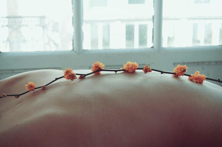 Soft bokeh effect on a relaxing spa scene with delicate flowers on skin.