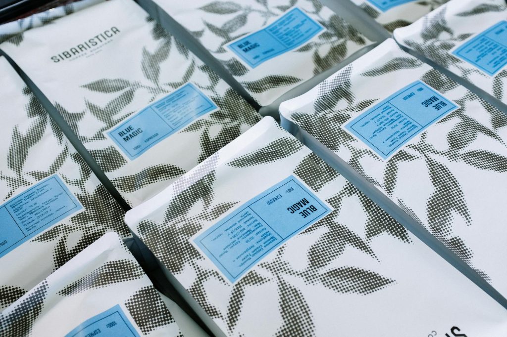 Close-up of branded coffee packages with artistic black and white leaf pattern.