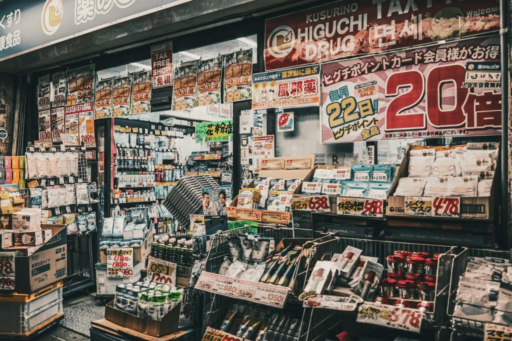 Vibrant display of a drugstore shopfront in Japan, showcasing a variety of products and sale signs.