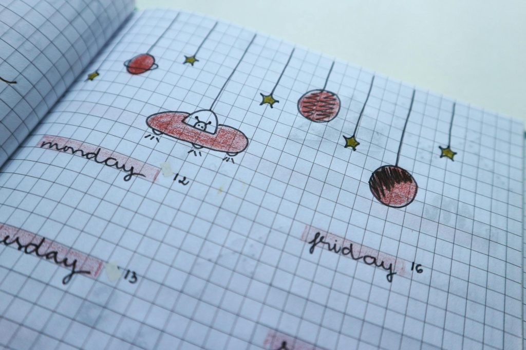 Close-up of a hand-drawn weekly planner page with cute, creative designs and grid layout.