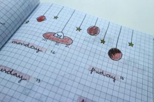 Close-up of a hand-drawn weekly planner page with cute, creative designs and grid layout.