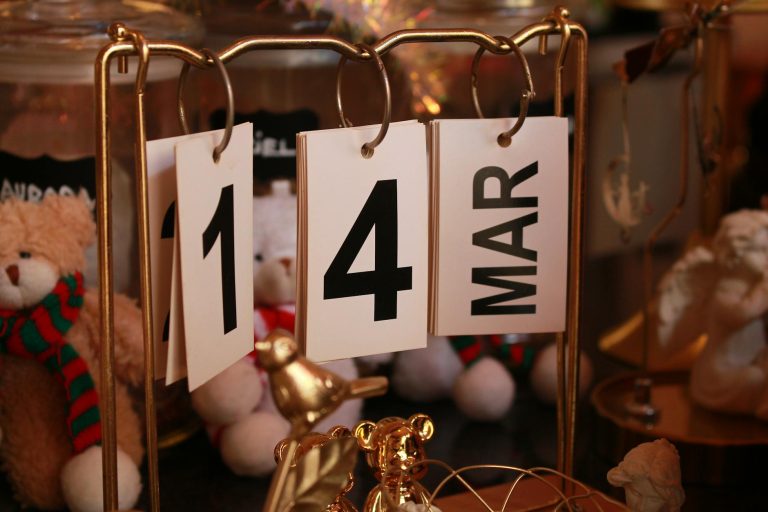 Close-up of a stylish desk calendar showing March 14, surrounded by decorative items.
