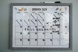Close-up of a whiteboard calendar for October 2024 featuring a fall break note.