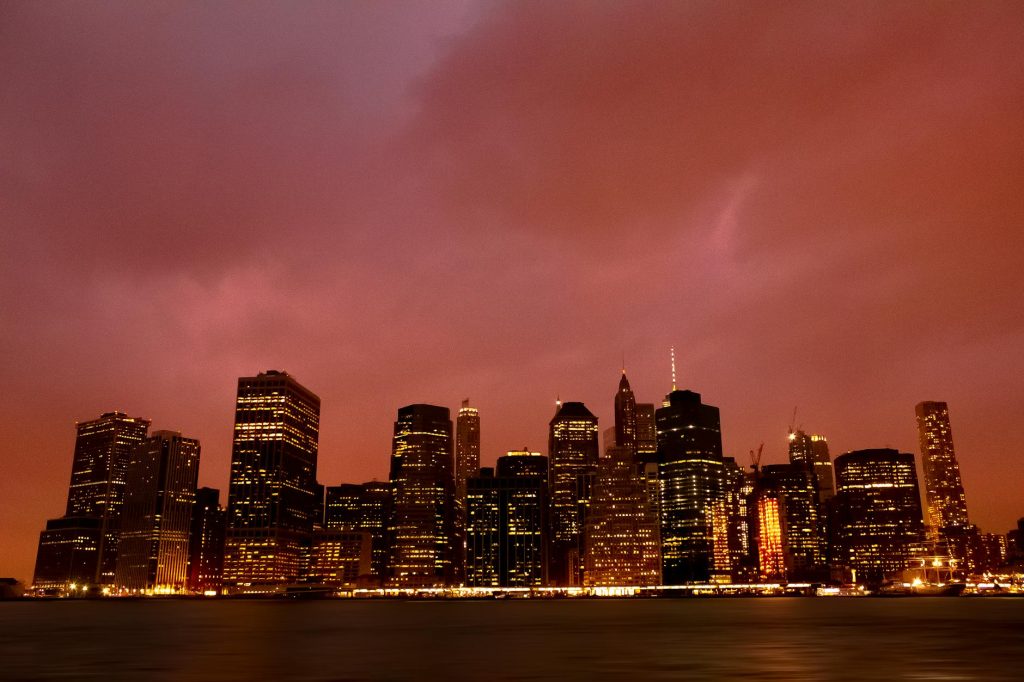 Beautiful view of the New York City skyline with city lights illuminating the dusk sky.
