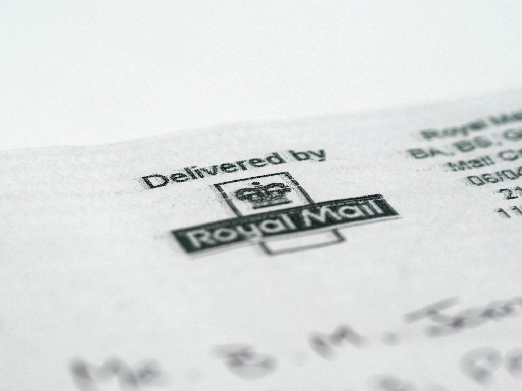 Macro shot of a Royal Mail stamp on a document highlighting postal delivery.