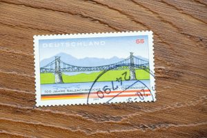 Vintage German stamp shows scenic bridge, highlighting design and postal history.