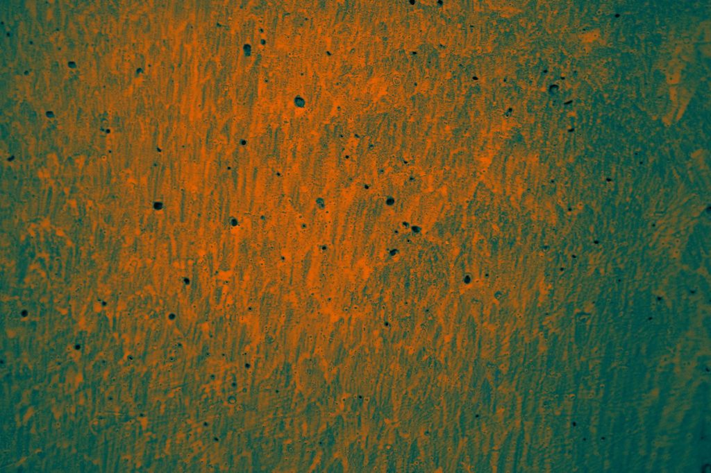An abstract orange texture with a pattern resembling a painted wall surface.