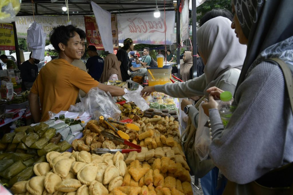 People buying snacks at a vibrant outdoor food market. A lively scene showcasing local cuisine.