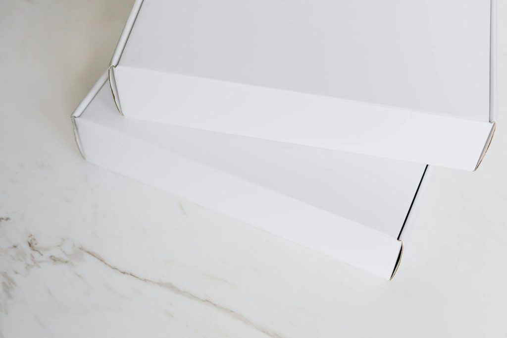 Two white cardboard boxes neatly stacked on a marble surface, ideal for online retail imagery.