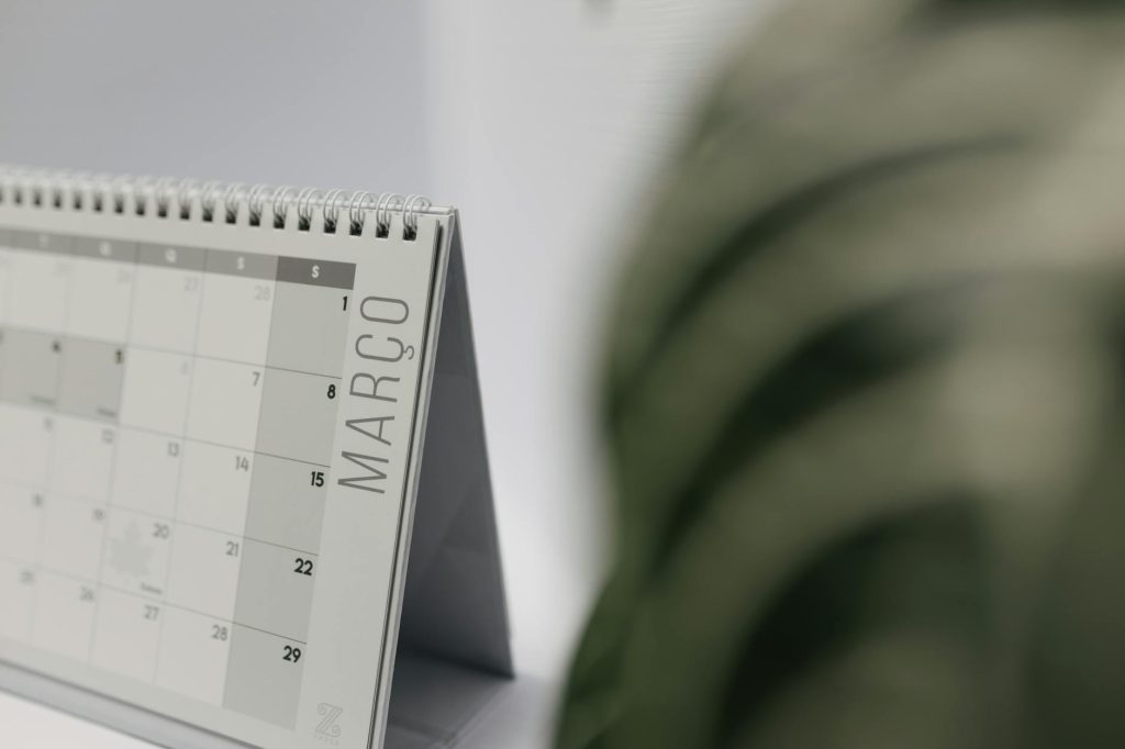 A close-up shot of a desk calendar open on March, with a soft, minimalistic background.