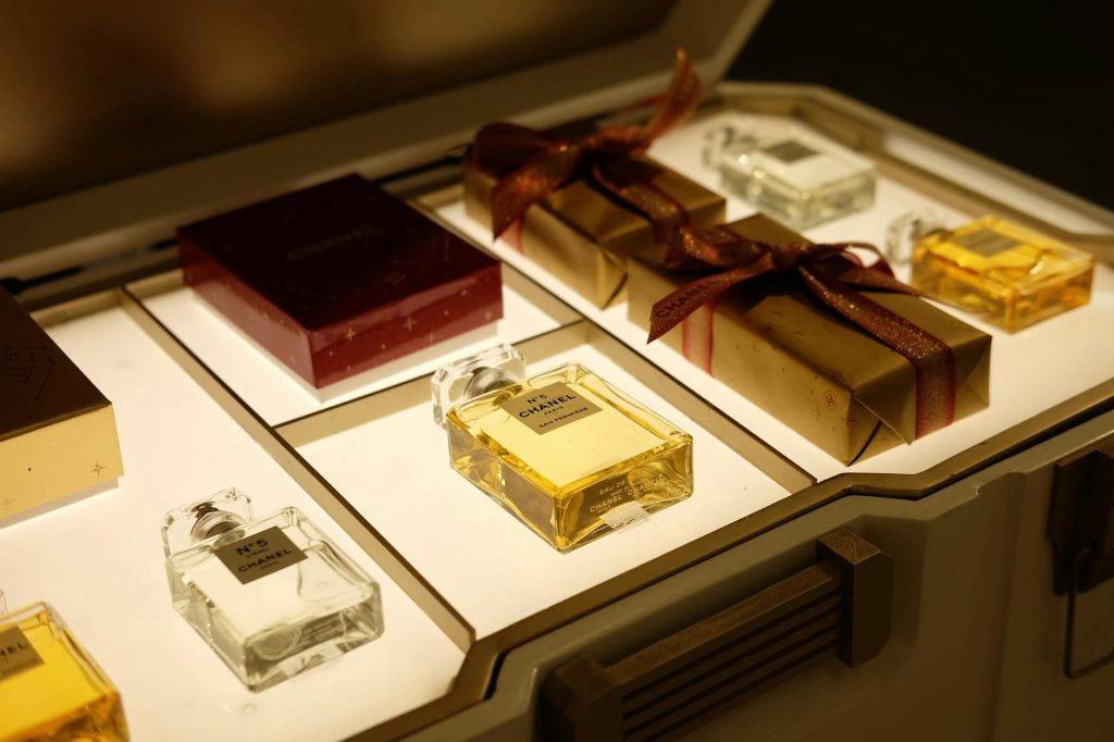Luxurious gift box featuring exquisite perfume bottles and wrapped presents, elegantly displayed.